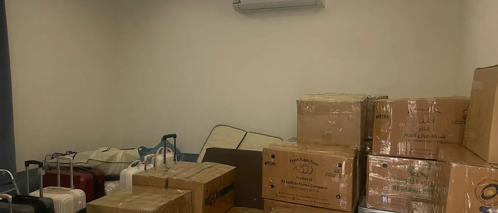 غرفة فيها حقائب سفر وكراتين مغلقة جاهزة ليوم الموعد مع شركات نقل العفش