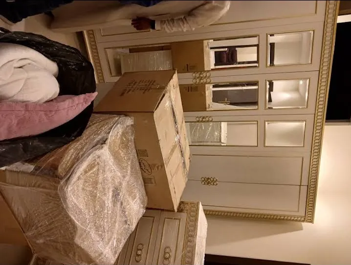 كراتين وأغراض مغلفة أمام تسريحة كلاسيكية بلون كريمي