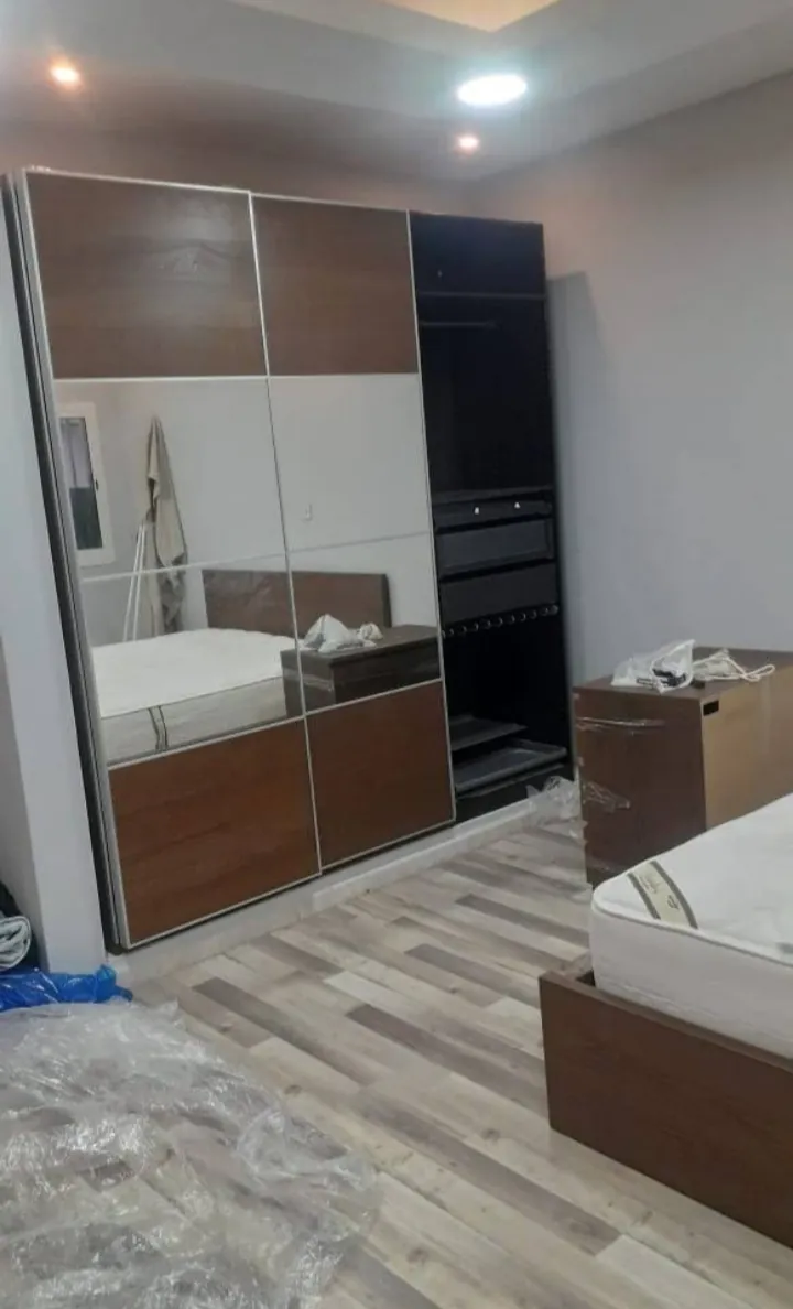 دولاب بأبواب منزلقة ومرايا وأرضية مغطاة بالنايلون أثناء التركيب